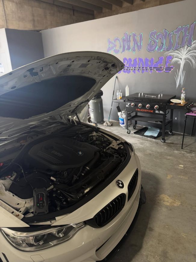 White BMW 440i with the hood up getting a Stage 2+ ECU tune in the shop