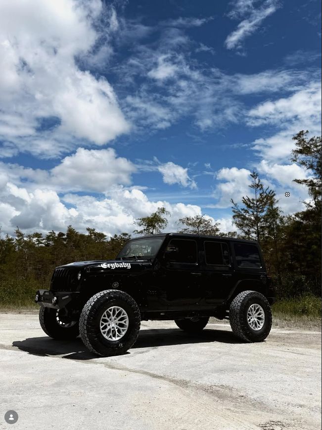Black lifted Jeep Wrangler Unlimited on off-road tires in the Everglades